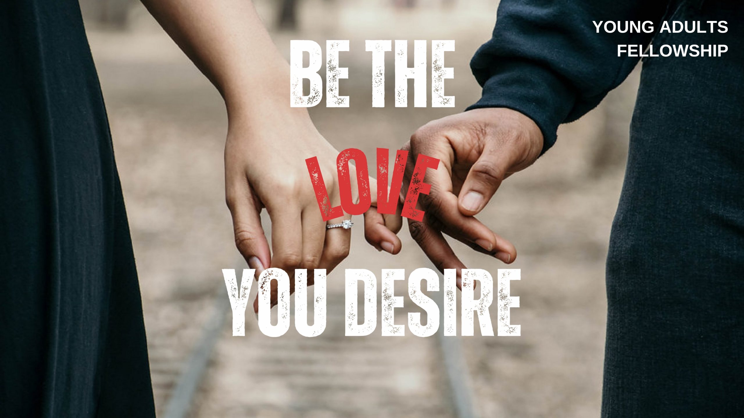 A man and woman stand with pinkie fingers interlocked